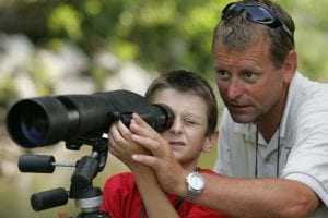 מבוגר עוזר לילד להשתמש בטלסקופ